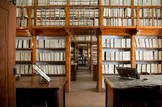 Interno dell'Archivio con librerie a parete ricolme di libri e registri