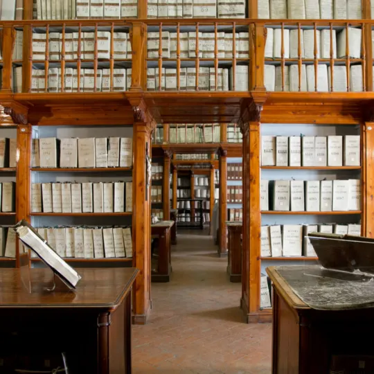 Interno dell'Archivio con librerie a parete ricolme di libri e registri