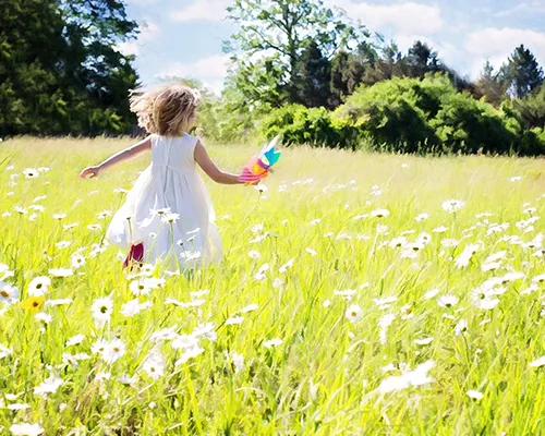 bambina che corre su un prato