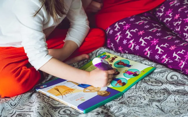 bambina che legge un libro insieme alla madre