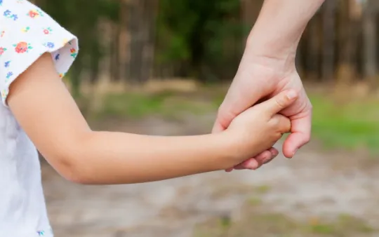 genitore che tiene per mano la figlia