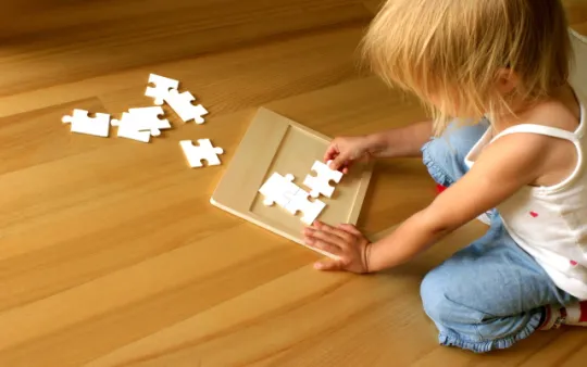 bambina che compone un puzzle