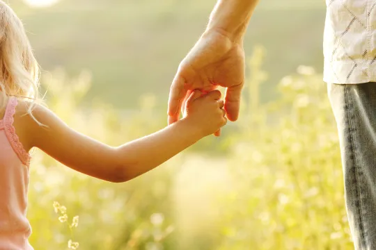 padre che prende per mano la figlia