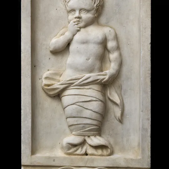 rilievo in pietra raffigurante putto in fasce ripreso nell'atto di avvicinare la mano destra alla bocca