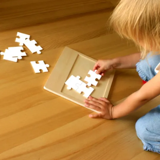 bambina che compone un puzzle