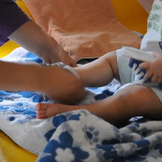 foto di un adulto che mette le scarpe a un bambino