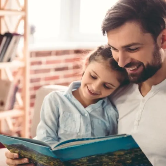 padre che legge un libro con la figlia per evocare il tema dell'affido al centro della Presentazione indirizzi operativi per l'affidamento familiare