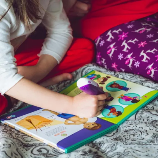 bambina che legge un libro insieme alla madre