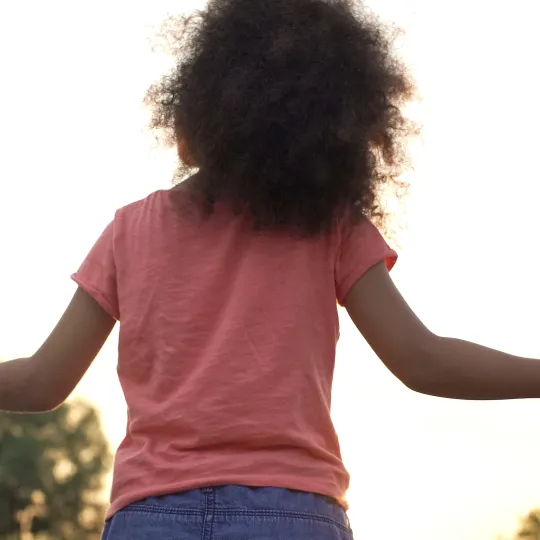 Bambina per mano a due adulti, visti di spalle
