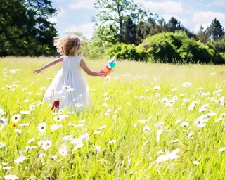 bambina che corre su un prato
